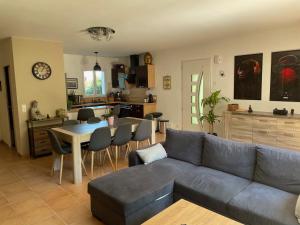 ein Wohnzimmer mit einem Sofa und einem Tisch mit Stühlen in der Unterkunft Maison au cœur du Pays Basque in Cambo-les-Bains