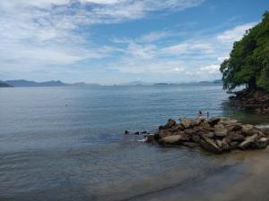 a group of people in the water on a beach at Aconchego Premium in Angra dos Reis
