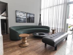 uma sala de estar com um sofá verde e uma mesa em Mercure Camboriu em Balneário Camboriú