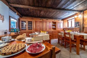 una cocina con armarios de madera y una mesa con comida. en Antica casa di montagna Maison Bovard, en Valgrisenche