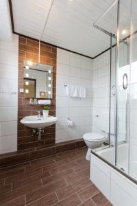 a bathroom with a sink and a toilet and a shower at Hotel Zum Jägerhaus in Vreden