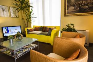 a living room with a yellow couch and a table at Hotel Regio in Rubiera