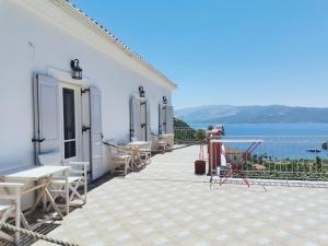 a white building with tables and chairs on a patio at Gardenia Apartments in Stavros