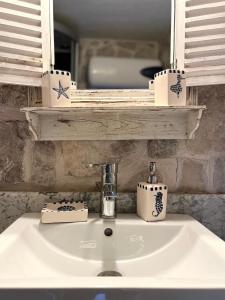 a white bathroom sink with a mirror and a sink at Una apartments in Kotor
