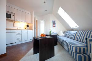 ein Wohnzimmer mit einem Sofa und einem Tisch in der Küche in der Unterkunft Inselresidenz Strandburg - Ferienwohnung 305 (Ref. 50973) in Juist