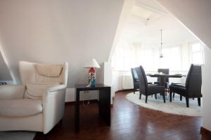 ein Wohnzimmer mit einem Stuhl und einem Esstisch in der Unterkunft Inselresidenz Strandburg - Ferienwohnung 305 (Ref. 50973) in Juist
