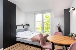 a bedroom with a bed and a table and a window at Smart Apartments - Old Town & Main Train Station in Krakow