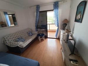 a small living room with a couch and a television at Apartamento en Cala de Finestrat in Cala de Finestrat