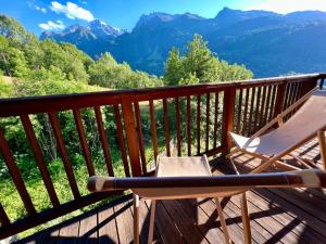 a deck with a chair and a view of mountains at Chalet Altus in Sainte-Foy-Tarentaise