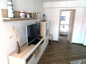 ein Wohnzimmer mit einem Flachbild-TV auf einem Entertainment-Center in der Unterkunft Inselresidenz Strandburg Juist - Turmwohnung 205 (Ref. 50959) in Juist