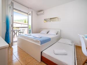 1 dormitorio con 2 camas y balcón en Apartments Prkačin en Starigrad-Paklenica