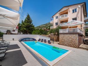a villa with a swimming pool and a building at Apartments Prkačin in Starigrad-Paklenica