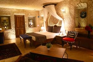 1 dormitorio con 1 cama, mesa y sillas en Pegas Cave Suites en Urgup