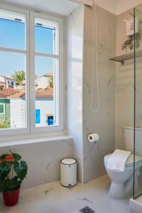 a bathroom with a toilet and a window at Galaxidaki 1857 guesthouse in Galaxidhion