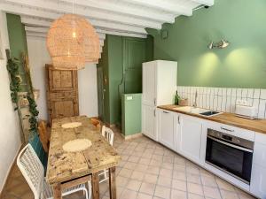 a kitchen with a table with chairs and a sink at La Galerie in Saint-Alban-de-Roche