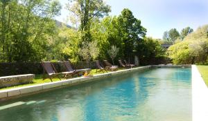 a swimming pool with lounge chairs in a yard at Château d'Uzer in Uzer