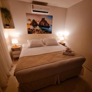 a bedroom with a bed with a painting on the wall at Flat Noronha Dreams in Fernando de Noronha