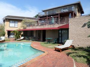 a house with a swimming pool in front of a house at Kingston Place Guesthouse in Durban