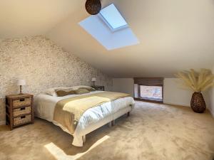 a bedroom with a bed and a skylight at La Galerie in Saint-Alban-de-Roche