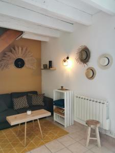 ein Wohnzimmer mit einem Sofa und einem Tisch in der Unterkunft Gîte entre Terre et Mer axe Rennes / Saint Malo in Langouet
