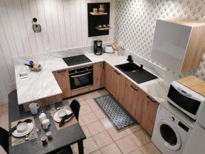 uma pequena cozinha com um lavatório e um fogão em Gîte entre Terre et Mer axe Rennes / Saint Malo em Langouet