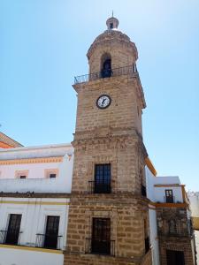 a clock tower on the side of a building at Apartamentos Plaza Santo Domingo in Cádiz