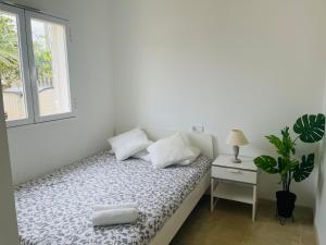 a white bedroom with a bed and a window at Beautiful independent house in Llucmajor