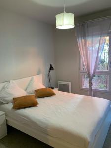 a bedroom with a large white bed with a window at Apparteo Marseille in Marseille