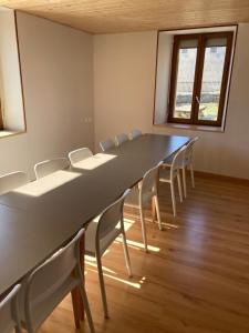 une salle de conférence avec une grande table et des chaises dans l'établissement Chez Hervé le Châtelet, à La Chaux Neuve