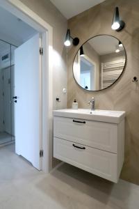 een badkamer met een wastafel en een spiegel bij Apartbaltic - Zdrojowa 51 STUDIO in Świnoujście