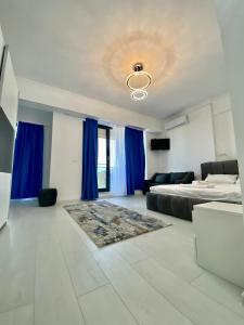 a large bedroom with a bed and blue curtains at Luxury Studio Solid Butoaie in Mamaia