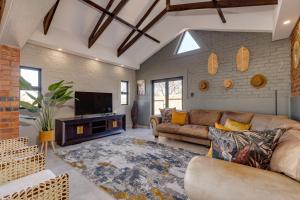 a living room with a couch and a flat screen tv at HAVANA VILLA - Pretoria East Luxury Villa in Pretoria