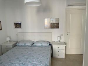 利帕里的住宿－Villa Portinente，一间卧室配有一张带2个床头柜和2盏灯的床。