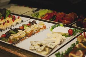 ein Buffet mit verschiedenen Speisen auf Platten in der Unterkunft Hotel Pod Lwem in Elblag