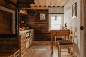 uma cozinha com paredes de madeira e uma mesa e cadeiras em Vienkiemio Oazė - Pasakų namelis em Galvokai