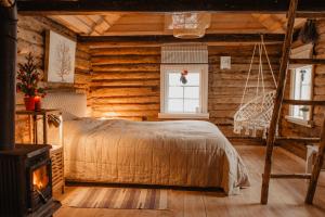 um quarto com uma cama num chalé de madeira em Vienkiemio Oazė - Pasakų namelis em Galvokai