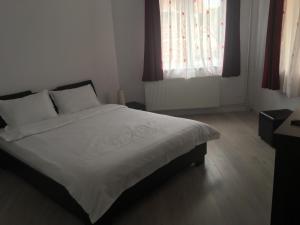 索瓦塔的住宿－Casa Julius，一间卧室配有白色床单和红色窗帘