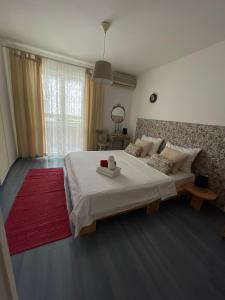 a bedroom with a large white bed with a red rug at Apartmani Zorica in Rab