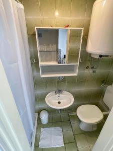 a small bathroom with a sink and a toilet at Apartmani Zorica in Rab