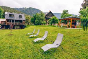a group of chairs sitting in the grass in front of a house at Chalet Valcanale in Camporosso in Valcanale