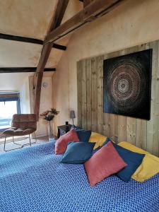 Un dormitorio con una cama con almohadas de colores. en Gîte entre Terre et Mer axe Rennes / Saint Malo, en Langouet