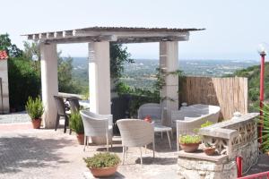 een patio met stoelen en een pergola bij Dimora in collina in Monopoli