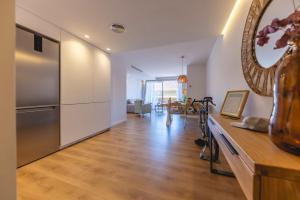 uma cozinha e sala de estar com um frigorífico de aço inoxidável em Bravissimo Domènica, 2 bedrooms and balcony em Girona