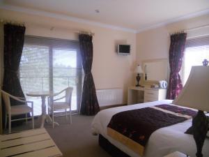 una camera d'albergo con un letto, un tavolo e delle sedie di B&B The Silver Eel a Strokestown