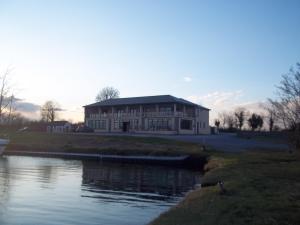 un grande edificio accanto a un corpo idrico di B&B The Silver Eel a Strokestown