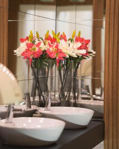 a vase of flowers on a bathroom counter with sinks at Hotel BLVD 7 in Plovdiv