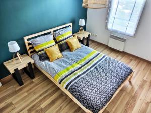 una camera da letto con un grande letto con cuscini gialli e blu di L'Ebenisterie - Sublime Type 2 Lumineux - Grand balcon a Orvault