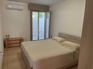 ein Schlafzimmer mit einem Bett und einem großen Fenster in der Unterkunft Appartamenti Torre Lapillo in Torre Lapillo