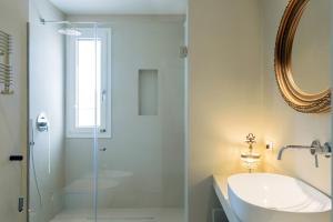 a bathroom with a glass shower and a sink at Domìa Boutique Hotel e Cucina in Mondello