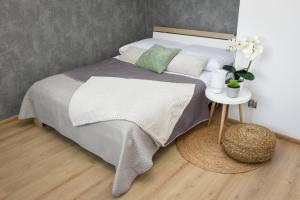 sypialnia z łóżkiem i stolikiem nocnym ze stołem w obiekcie Apartamenty Legionów 30 w Oświęcimiu